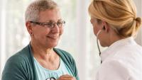 doctor listening senior woman's heart using stethoscope